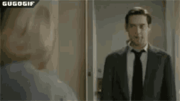 a man in a suit and tie is standing in front of a mirror and says soy putazo
