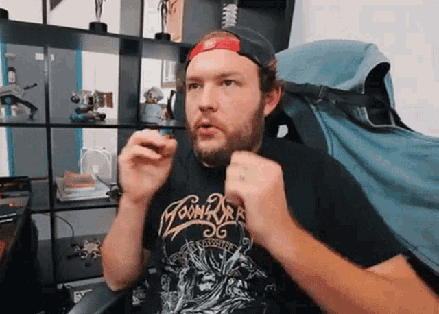 a man with a beard wearing a black shirt with the word moon on it