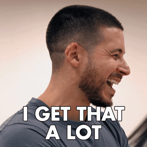 a man with a beard is laughing with the words " i get that a lot " above him