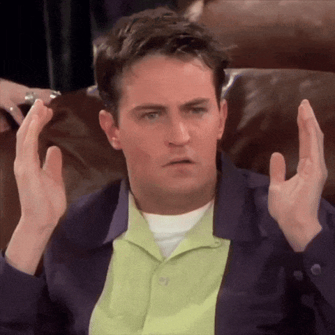 a man sitting on a couch with his hands up