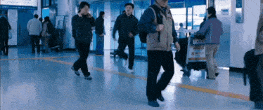 a group of people walking in a hallway with a sign on the wall that says ' subway '