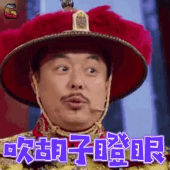 a man wearing a red hat with chinese writing on it is making a funny face .