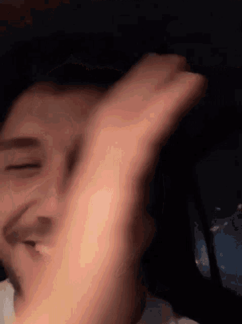 a close up of a person 's face with their hand on their head