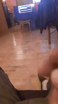a person is sitting on a wooden floor in front of a blue box with the letter l on it
