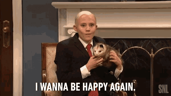a man in a suit and tie is holding an opossum and saying i wanna be happy again