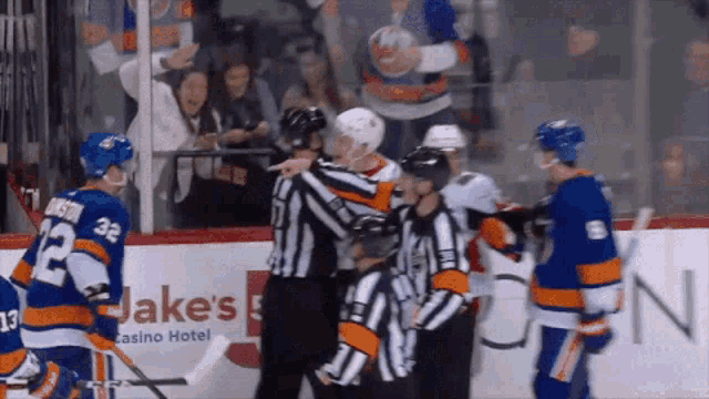 a hockey game is being played in front of an ad for jakes casino hotel