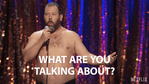 a shirtless man stands in front of a microphone with the words " what are you talking about " below him