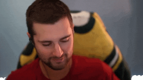 a man in a red shirt is sitting in front of a yellow and black shirt .