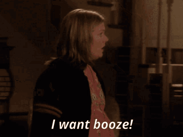 a woman says " i want booze " while standing on a staircase