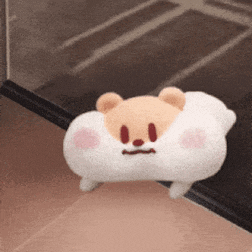 a stuffed animal that looks like a bear is sitting on the floor .