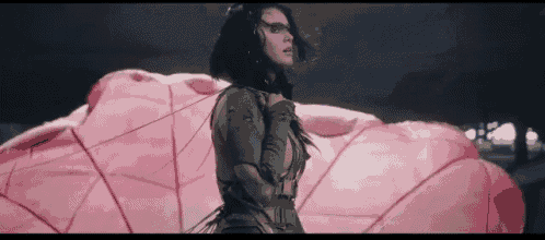 a woman is standing in front of a pink object .
