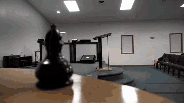 a chess piece sits on a table in front of a podium in an empty room