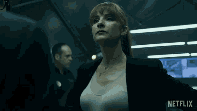 a woman is smiling in a dark room with netflix written on the bottom
