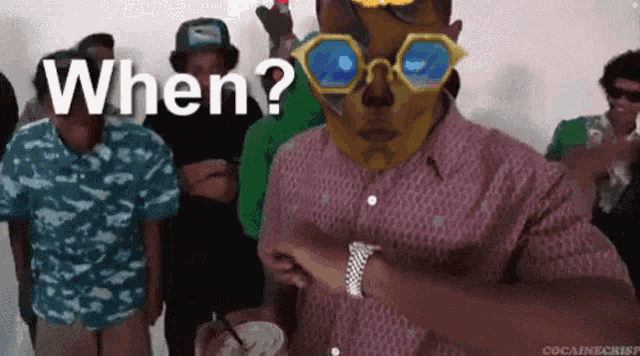 a group of people are standing around a man wearing sunglasses and a mask that says when on it