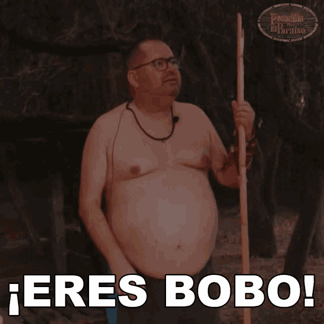 a man without a shirt is holding a stick and says " eres bobo "