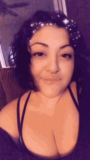 a woman with a nose ring is wearing a black bra