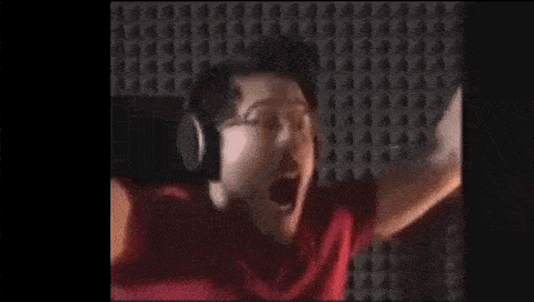 a man in a red shirt is yawning with his mouth open and his arms in the air .