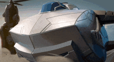 a gray and blue military helicopter is flying in the sky