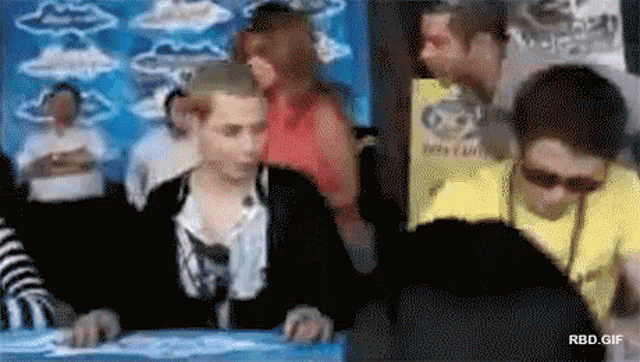 a group of people are gathered around a table with a sign that says rbd.gif on the bottom