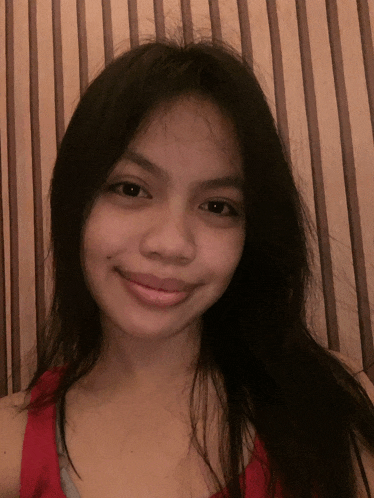 a girl with long black hair is smiling for the camera
