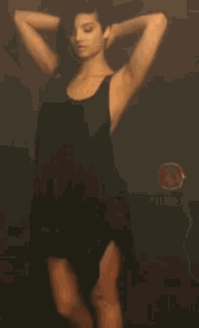 a woman in a black dress is dancing on a stage .