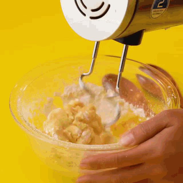 a person is mixing something in a bowl with a mixer with the number 2 on it