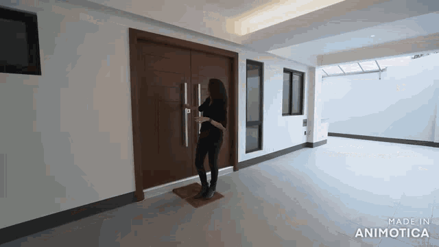 a woman is standing in a hallway in front of a door .