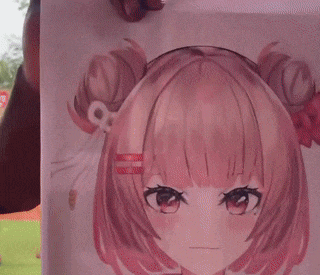a man is holding a picture of an anime girl with pink hair