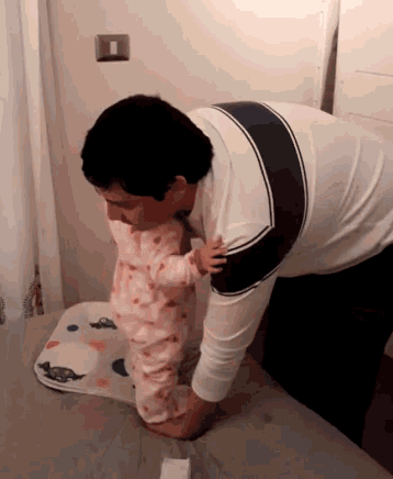 a man is holding a baby on a bed