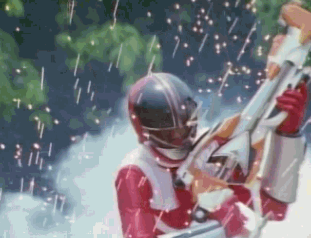 a red power ranger is holding a sword in his hand in the rain while wearing a helmet .