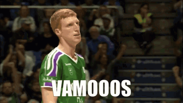 a man wearing a green and purple jersey with the word vamos on it
