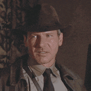 a man wearing a hat and tie looks at something