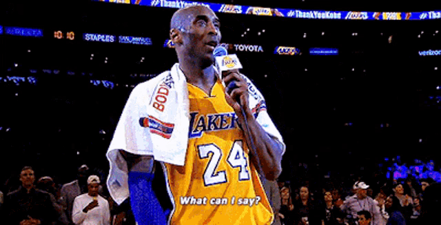 a man wearing a lakers jersey is holding a microphone