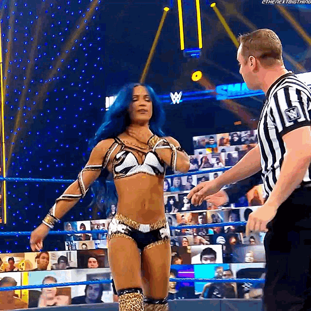 a woman in a wrestling ring with a referee