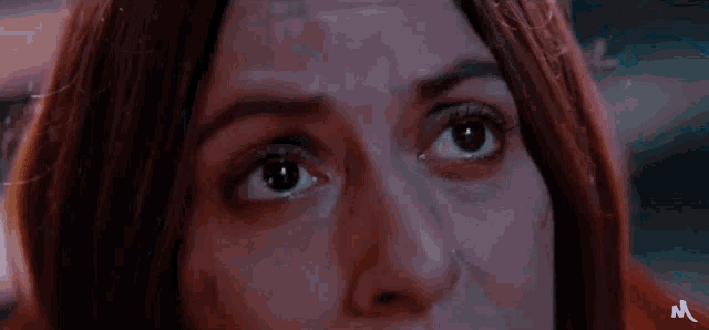 a close up of a woman 's face with the letter m on the bottom