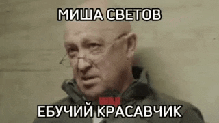 a bald man wearing glasses and a black jacket with a foreign language caption