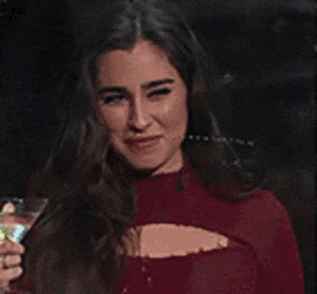 a woman holding a martini glass in front of a window
