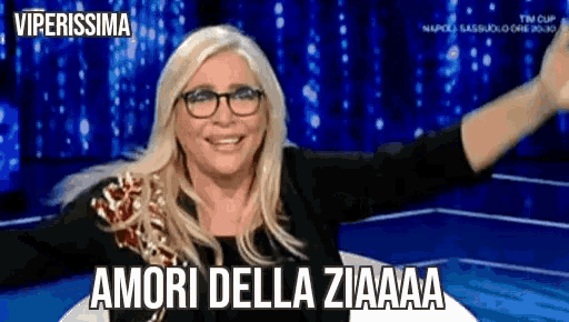 a woman wearing glasses is smiling with her arms outstretched and the words amori della ziaaa on the bottom