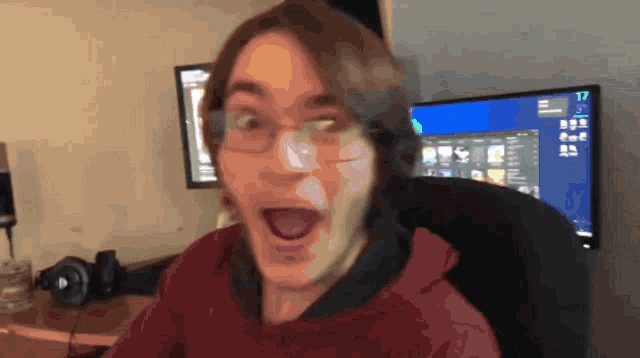 a man making a funny face in front of a computer monitor that says 17 on it
