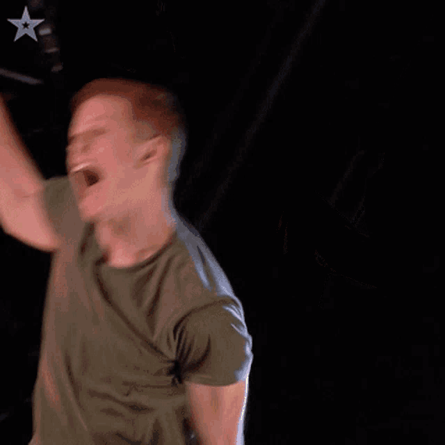 a man is singing into a microphone with a star in the background