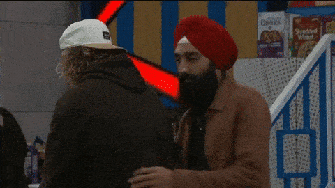 a man in a turban is hugging another man