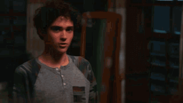 a man with curly hair wearing a grey shirt