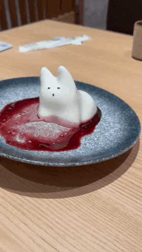 a plate of food with a cat shaped dessert on top