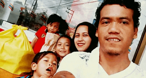 a man and a woman are posing for a picture with their three children .