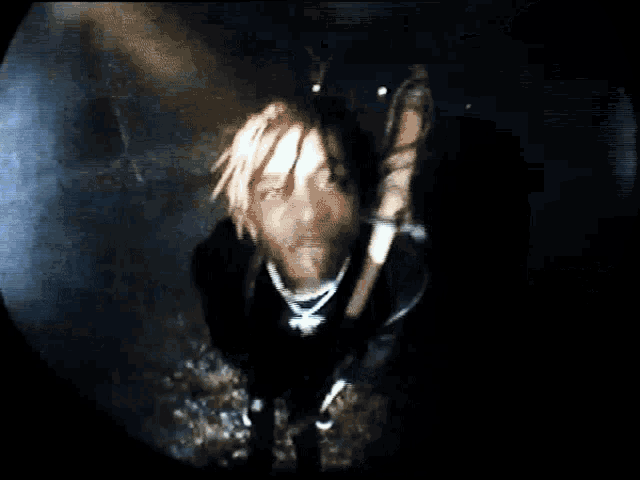 a man with dreadlocks is holding a sword in his hand
