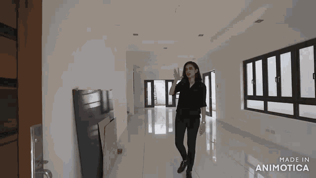 a woman standing in an empty room with the words made in animatica on the bottom right