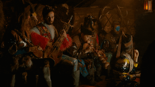 a group of men are playing musical instruments including a guitar and a flute