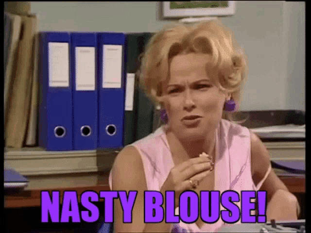a woman in a pink blouse is sitting at a desk and says nasty blouse !