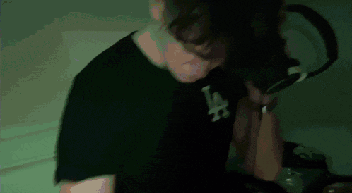 a man in a black shirt is playing a keyboard with purple and green lights
