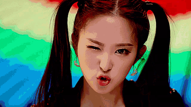 a close up of a woman with pigtails making a funny face
